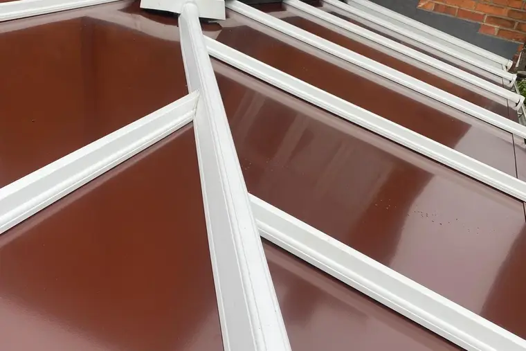 Close view of a brown insulated panel conservatory roof with white glazing bars