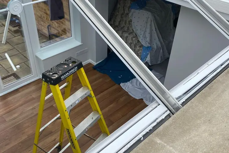 Conservatory roof frame opened up during installation, with a stepladder inside