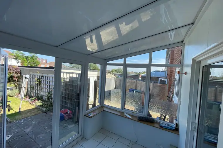 Lean-to conservatory with a white insulated panel ceiling and a pale ceramic floor