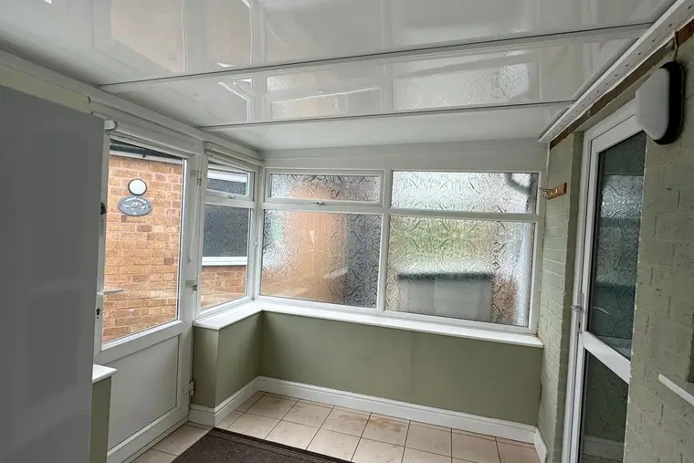Small lean-to conservatory with a new white panel roof and a ceramic floor