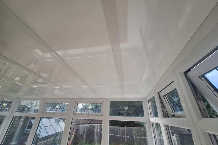 Wide view of a smooth white panel ceiling inside a lean-to conservatory