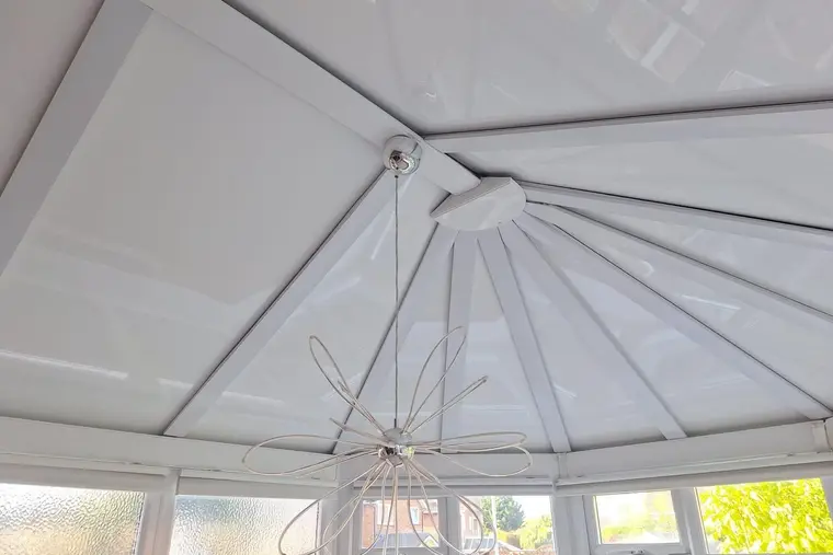 White insulated panel ceiling with a wire pendant light inside a Victorian conservatory